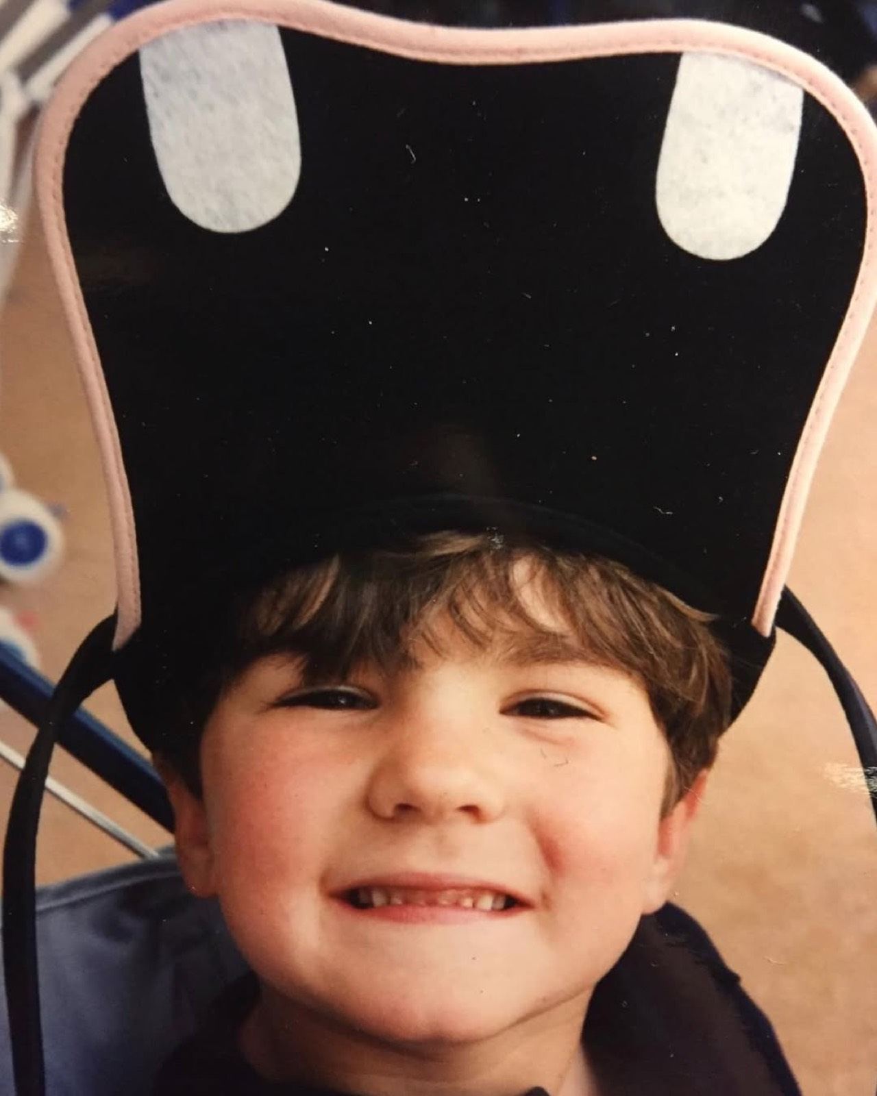 James as a small boy, grinning under an oversized novelty hat